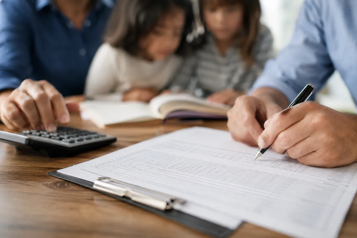 Carte Vitale et feuilles de remboursement posées sur un bureau à côté d'un carnet de santé enfant